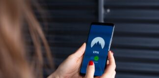 Konfiguracja własnego VPN w chmurze na VPS: tanie, szybkie i prywatne rozwiązanie krok po kroku Kobieta trzyma smartfon z włączoną aplikacją VPN, symbol bezpieczeństwa online