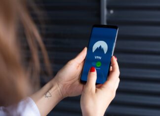 Konfiguracja własnego VPN w chmurze na VPS: tanie, szybkie i prywatne rozwiązanie krok po kroku Kobieta trzyma smartfon z włączoną aplikacją VPN, symbol bezpieczeństwa online