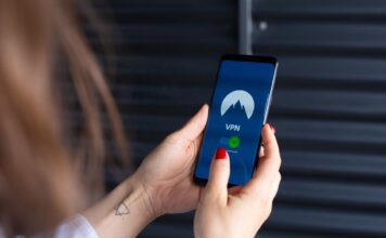 Kobieta trzyma smartfon z włączoną aplikacją VPN, symbol bezpieczeństwa online