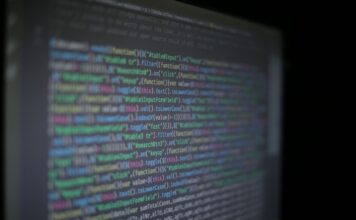 Języki programowania w cyberbezpieczeństwie: co naprawdę warto znać Kolorowy kod programistyczny na rozmytym ekranie monitora