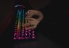 Najlepsze klawiatury mechaniczne do pisania kodu – porównanie przełączników i ergonomii Dłonie piszące na mechanicznej klawiaturze RGB w ciemnym otoczeniu