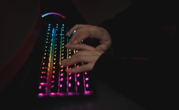 Najlepsze klawiatury mechaniczne do pisania kodu – porównanie przełączników i ergonomii Dłonie piszące na mechanicznej klawiaturze RGB w ciemnym otoczeniu