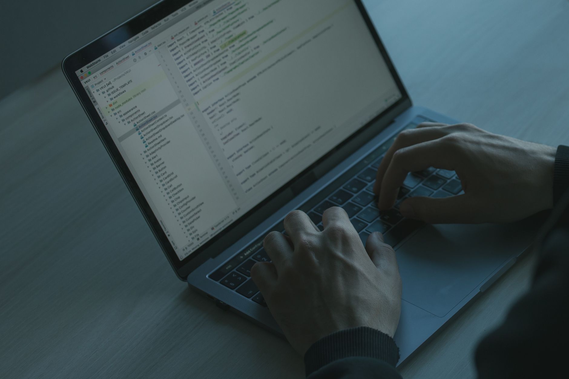 Programista piszący kod zabezpieczeń JS na laptopie