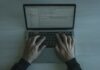 Bezpieczeństwo w świecie frameworków JS: konfiguracje, biblioteki ochronne i dobre praktyki DevSecOps Programista piszący kod zabezpieczeń JS na nowoczesnym laptopie