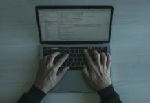 Programista piszący kod zabezpieczeń JS na nowoczesnym laptopie