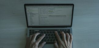 Programista piszący kod zabezpieczeń JS na nowoczesnym laptopie