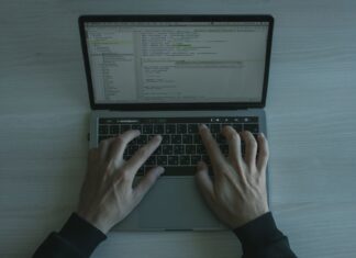 Bezpieczeństwo w świecie frameworków JS: konfiguracje, biblioteki ochronne i dobre praktyki DevSecOps Programista piszący kod zabezpieczeń JS na nowoczesnym laptopie