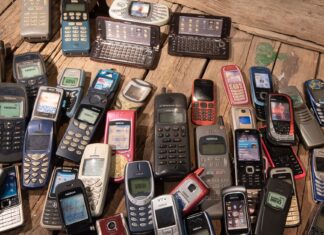 Od pagera do smartfona: historia urządzeń mobilnych, które połączyły świat online i offline Zestaw retro telefonów komórkowych na drewnianym blacie
