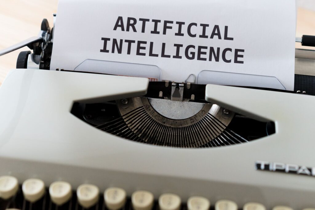 Zbliżenie na maszynę do pisania z napisem Artificial Intelligence na kartce